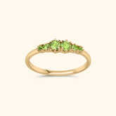 Goudkleurige ring met zes heldergroene peridot stenen in oplopende grootte, gezet in gold plated messing.